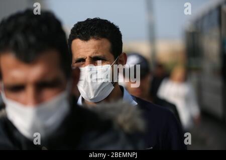 Manouba, Tunisia. 14th Apr, 2020. Workers wear face masks while arriving at factory on Apr. 14, 2020 in Industrial Zone Agba, Manouba, Tunisia. After the announcement of total containment throughout Tunisia on March 22, 2020, factories and viral sectors are continuing their activities while respecting the precautions against the pandemic of CoViD-19. This story follows the daily routine of workers at Marquardt Tunisia automotive factory in Manouba, Tunisia during the Covid-19 coronavirus pandemic. (Photo by Mohamed Krit/Sipa USA) Credit: Sipa USA/Alamy Live News Stock Photo