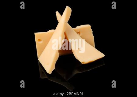 Pieces of Cheese isolated on a grey background. With Clipping Path. British yellow Chester creme cheese made from cow milk close up. Stock Photo