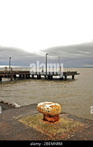 Old docking bollard in front of abandoned concrete landing stage at the entrance to Fleetwood docks Stock Photo