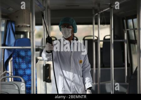 Manouba, Tunisia. 14th Apr, 2020. A cleaning worker disinfects the workers' bus on Apr. 14, 2020 in Industrial Zone Agba, Manouba, Tunisia. After the announcement of total containment throughout Tunisia on March 22, 2020, factories and viral sectors are continuing their activities while respecting the precautions against the pandemic of CoViD-19. This story follows the daily routine of workers at Marquardt Tunisia automotive factory in Manouba, Tunisia during the Covid-19 coronavirus pandemic. (Photo by Mohamed Krit/Sipa USA) Credit: Sipa USA/Alamy Live News Stock Photo