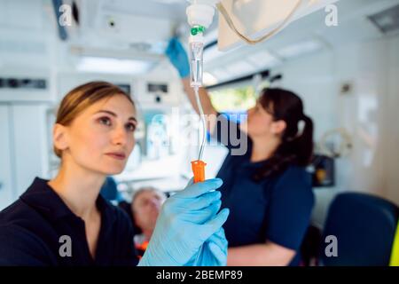 Paramedic looking after the drop injection in an ambulance Stock Photo