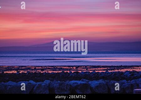 Heysham, Lancashire, United Kingdom. 14th Apr, 2020. Spectacular after glow behind the South Lakeland Fells, across Morecambe Bay brings to a close Tuesday. Credit: Photographing North/Alamy Live News Stock Photo