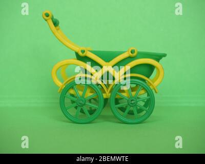 empty green plastic toy baby pushchair (aka stroller) Stock Photo