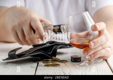 desperate man falls into depression and becomes alcoholic and miserable. His addiction leads him to a state of loneliness and poverty Stock Photo