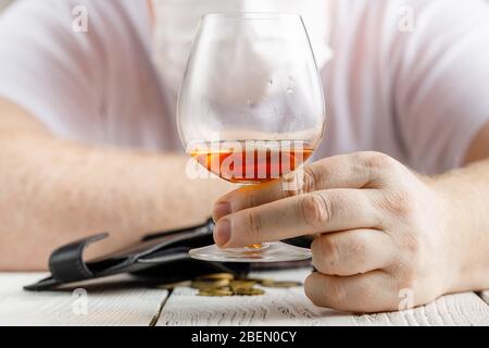 desperate man falls into depression and becomes alcoholic and miserable. His addiction leads him to a state of loneliness and poverty Stock Photo
