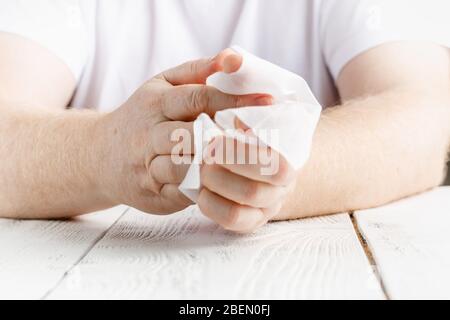 Close up on midsection of man hands wiping using white alcohol tissue cleaning napkin disinfection from virus and bacteria in day at home or office Stock Photo