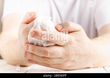 Close up on midsection of man hands wiping using white alcohol tissue cleaning napkin disinfection from virus and bacteria in day at home or office Stock Photo