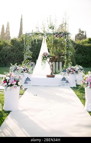 Wedding arch. Rustic wedding. Wedding area covered with flowers. Stock Photo