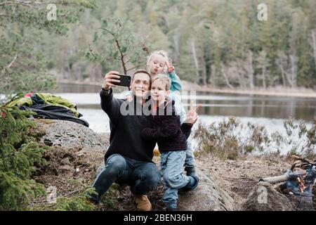 father taking pictures with his kids whilst hiking in Sweden Stock Photo