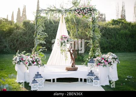 Wedding arch. Rustic wedding. Wedding area covered with flowers. Stock Photo