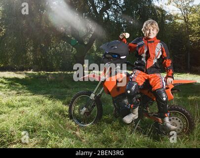 12 year old boy having a break on his off road motorbike Stock Photo