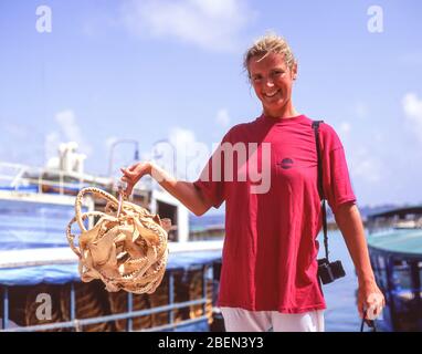 Young woman holding a bunch of shark's teeth, Male, Kaafu Atoll, Republic of Maldives Stock Photo