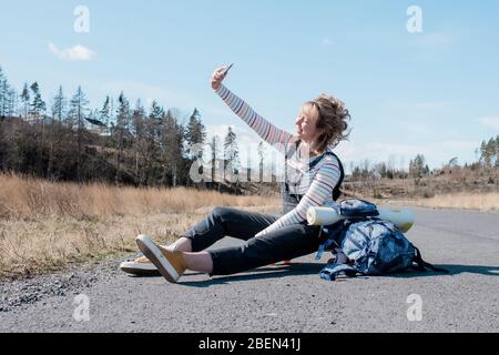 woman taking a selfie whilst taking a rest from skating from yoga Stock Photo