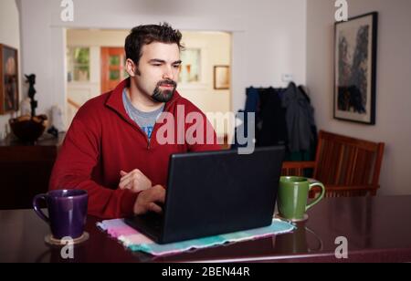 Man working on laptop computer from home Stock Photo