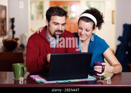 Couple work on laptop computer at home Stock Photo