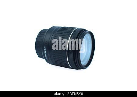 Close up of a black color camera lens of a digital camera placed over an isolated white background Stock Photo