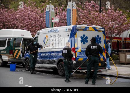 Brooklyn, United States. 14th Apr, 2020. EMS workers clean and disinfect their ambulance outside Brooklyn hospital amid the coronavirus outbreak in NY. As the curve flattens, New York continues to see high daily death tolls, recording once again over 700 coronavirus deaths yesterday. Credit: SOPA Images Limited/Alamy Live News Stock Photo