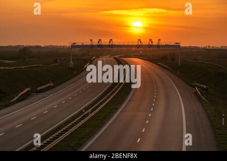 setting sun over an empty highway Stock Photo