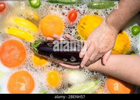 Fruit and vegetables washing in soapy water for coronavirus disinfection. Stock Photo