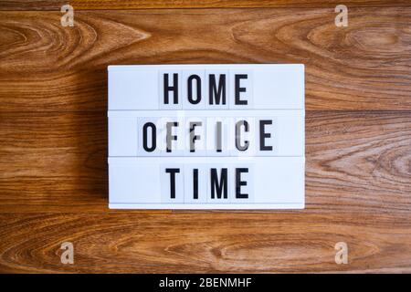 lightbox with text HOME OFFICE TIME in front wooden background, copy space, banner for freelance coronavirus covid-19 quarantine isolation Stock Photo