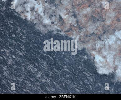 Fragment of an unusual stone, the combination of two marble and granite texture of dark and light color. Background. Stock Photo