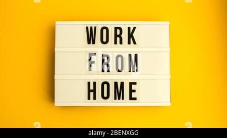 lightbox with text WORK FROM HOME in front yellow background, copy space, banner for freelance coronavirus quarantine isolation Stock Photo