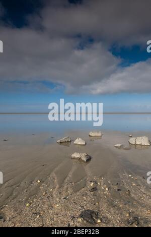 A soothing picture of the wadden sea at paesens moddergat, big rock in foreground, sea and sky. Stock Photo