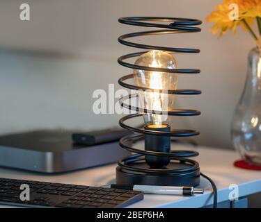 Vintage Iron Spiral Lamp in modern Home Office Environment Close-up View Stock Photo