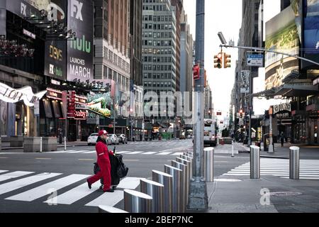Sanitation worker in Times Square area streets, empty & void; theaters/restaurants/businesses have been shut down to prevent the spread of COVID-19. Stock Photo