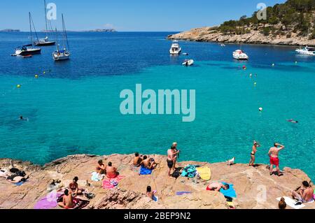 SAN ANTONIO, SPAIN - JUNE 18: Sunbathers at Cala Salada beach on June 18, 2015, in San Antonio, Ibiza Island, Spain. Ibiza is a well-known summer tour Stock Photo