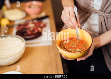 Housewife making quick easy homemade tomato pizza sauce from scratch.Traditional pizza base salsa recipe.Gourmet ketchup.Cooking and baking food at ho Stock Photo