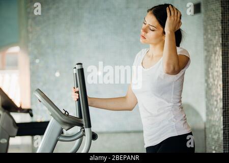 Woman doing fitness exercises on stepper at gym.Young woman making an effort and training hard for fit body.Excess body weight.Home aerobics workout. Stock Photo