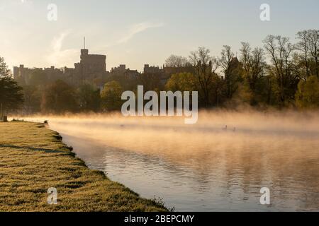 Eton, Windsor, Berkshire, UK. 15th April, 2020. After a cold night early morning mist swirls across the River Thames after sunrise with views of Windsor Castle and St George's Chapel.  Credit: Maureen McLean/Alamy Live News Stock Photo