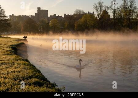 Eton, Windsor, Berkshire, UK. 15th April, 2020. After a cold night early morning mist swirls across the River Thames after sunrise with views of Windsor Castle and St George's Chapel.  Credit: Maureen McLean/Alamy Live News Stock Photo