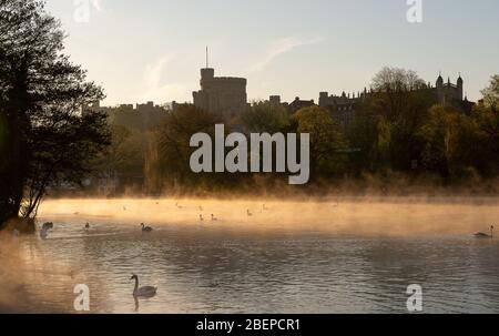 Eton, Windsor, Berkshire, UK. 15th April, 2020. After a cold night early morning mist swirls across the River Thames after sunrise with views of Windsor Castle and St George's Chapel.  Credit: Maureen McLean/Alamy Live News Stock Photo