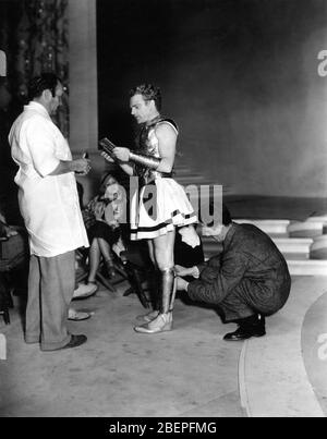 JAMES CAGNEY has his costume adjusted by Make-Up Men while his Wife BILLIE / FRANCES CAGNEY looks on set candid during filming of A MIDSUMMER NIGHT'S DREAM 1935 directors MAX REINHARDT and WILLIAM DIETERLE from the play by William Shakespeare Warner Bros. Stock Photo