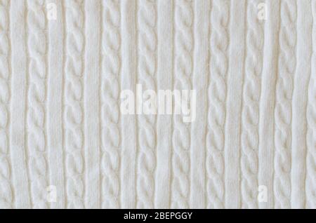Beige knitted woolen background. Knitwear fabric texture. Scandinavian minimalism backdrop with copy space, top view Stock Photo
