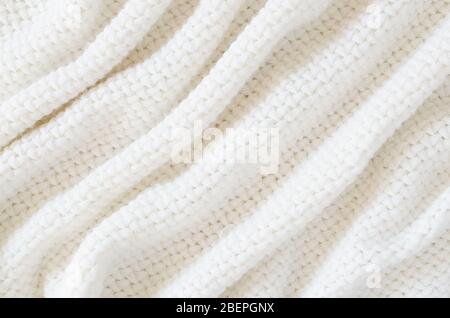 Beige knitted woolen background. Knitwear fabric texture. Scandinavian minimalism backdrop with copy space, top view Stock Photo