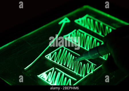 Bar graph of growth drawn with fluorescent marker on black background Stock Photo