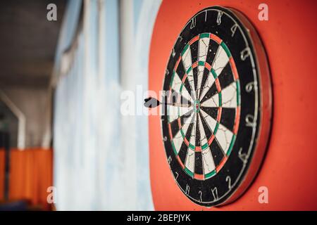 Dart arrow hitting in bulls eye on dartboard.Success hitting target aim goal achievement concept.Indoor game,played at home. Stock Photo