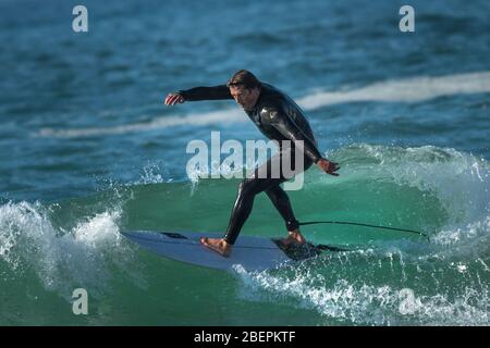 A Mature male surfer riding a wave at Fistral in Newquay in Cornwall. Stock Photo