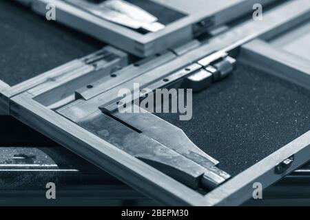 Steel calipers in cases are on a table, blue toned close-up photo with selective focus Stock Photo