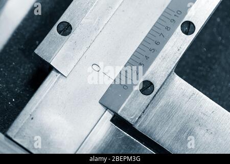 Analog calipers fragment with scale and zero line, close-up blue toned photo with selective focus Stock Photo