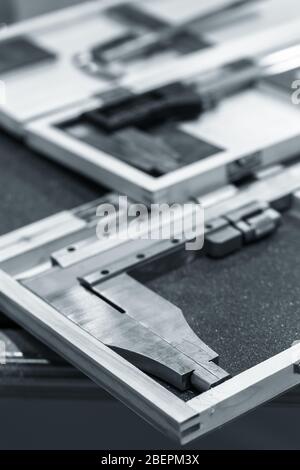 Analog calipers in cases are on a table, blue toned close-up vertical photo with selective focus Stock Photo