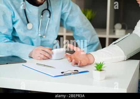 Doctor measures the pressure of the patient in clinic. Stock Photo