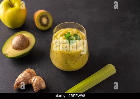 Freshly made green smoothie made of vegetables, fruits, herbs and greens on a dark background. Copy space Stock Photo