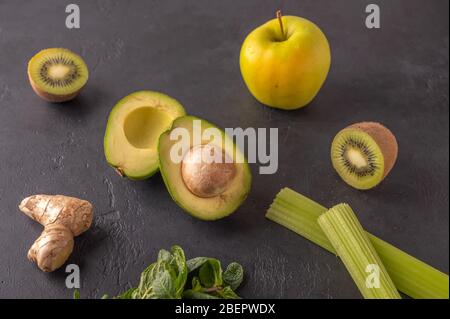 Ginger, avocado, apple, kiwi, celery on a dark background. Ingredients for smoothies. Healthy food Stock Photo
