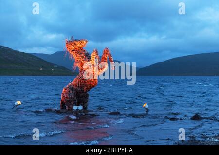 Incredible evening scene with luminous mythical horse Nykur Nix Statue in Sorvagsvatn lake waters near the airport in Vagar on the Faroe Islands, Denmark Stock Photo