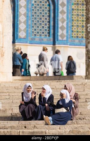 Four muslim girls sitting on steps at the Dome of the Rock in Jerusalem, Israel Stock Photo