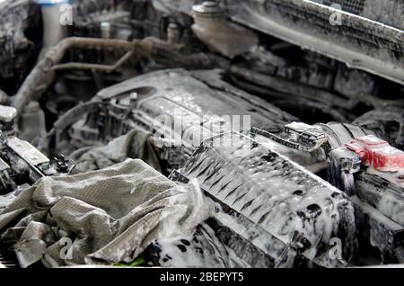 Wash the engine with car wash foam.Clean the engine at the car care shop. Stock Photo